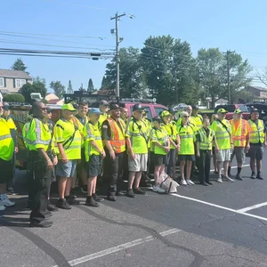 Volunteer fire police posing together in a parking lot beside a fire truck